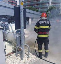 O mașină a luat foc în parcarea unui supermarket
